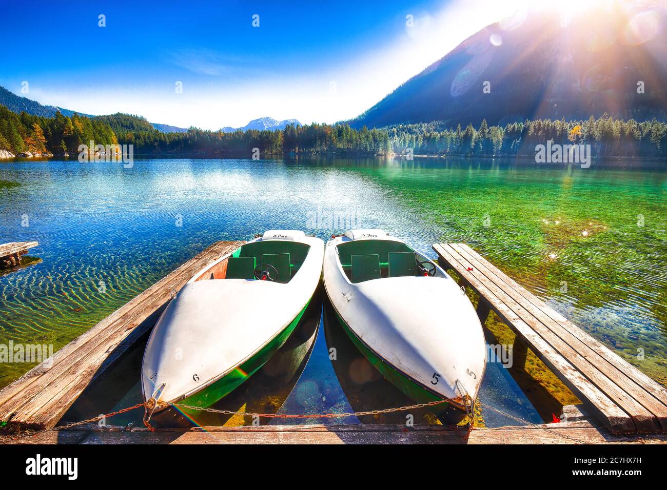 Fantástica mañana de otoño en el lago Hintersee. Pocos barcos en el lago con agua turquesa del lago Hintersee. Ubicación: resort Ramsau, Parque Nacional Berch Foto de stock