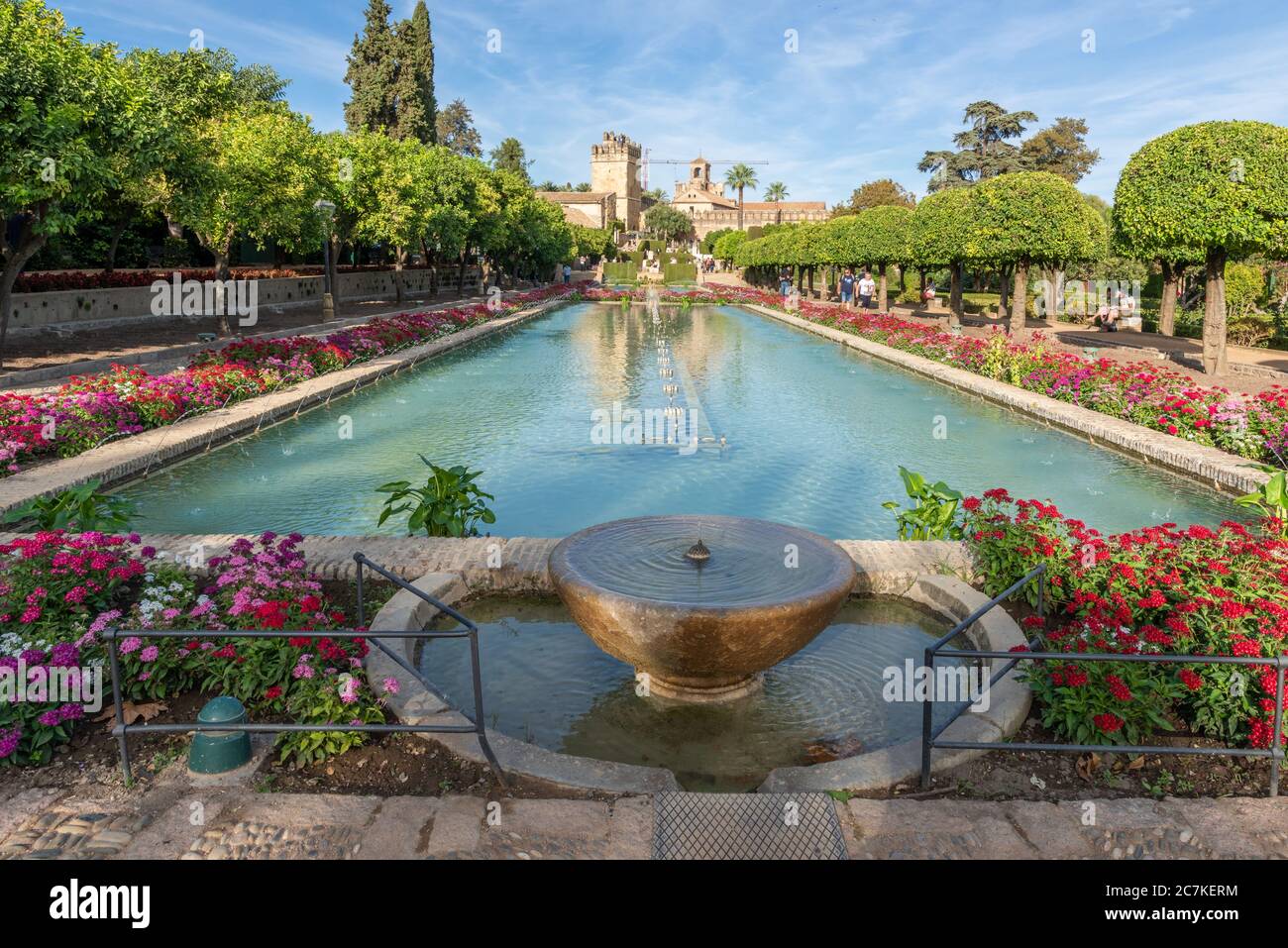 Una vista a lo largo de las piscinas de los Jardines del Alcázar hacia las torres del histórico Alcázar de los Reyes Cristianos Foto de stock