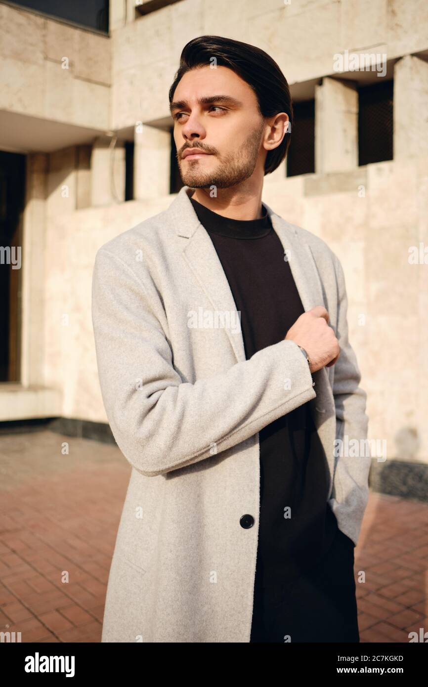 Joven hombre guapo en abrigo con confianza mirando al aire libre Fotografía  de stock - Alamy