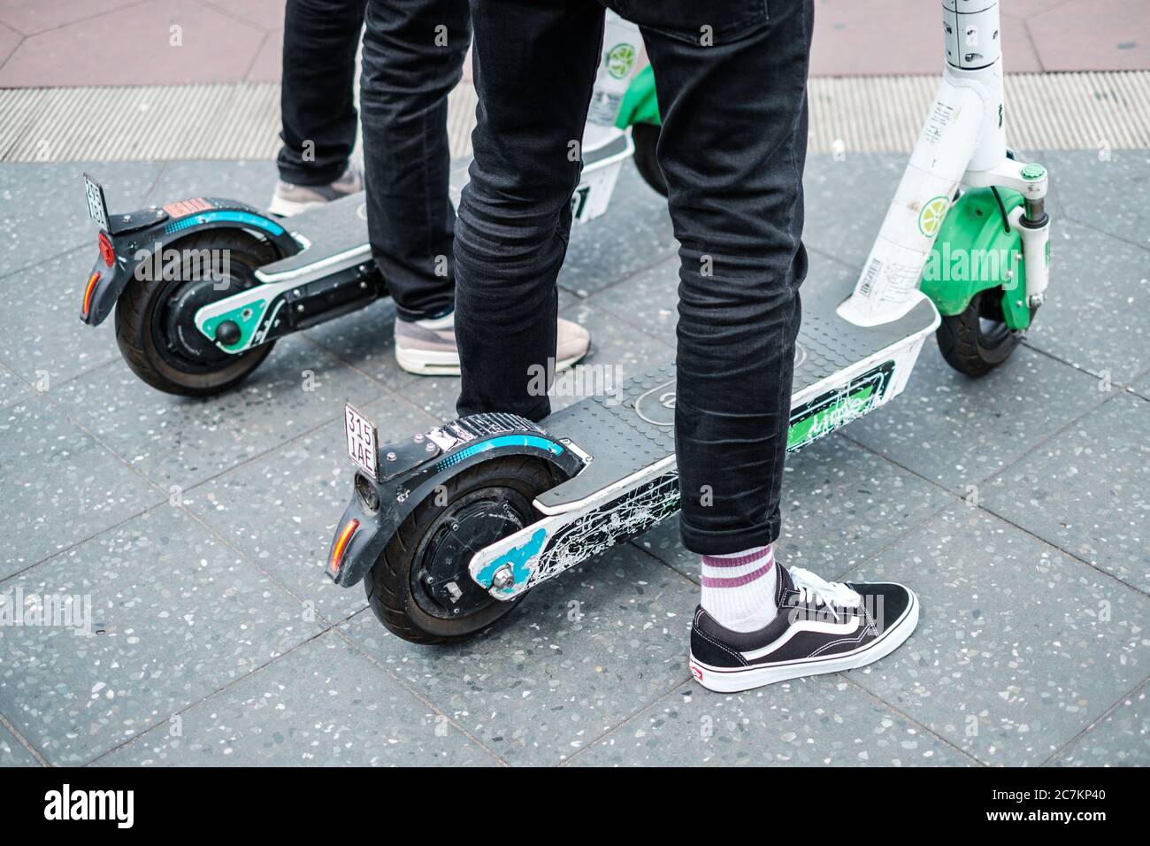 Berlín, Alemania - Julio de 2020: Cierre de una persona que usa un E-scooter de Lime o scooter eléctrico Foto de stock