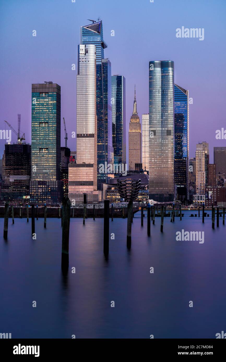 Tiro vertical de hermosos rascacielos en una ciudad urbana con el cielo púrpura en el fondo Foto de stock