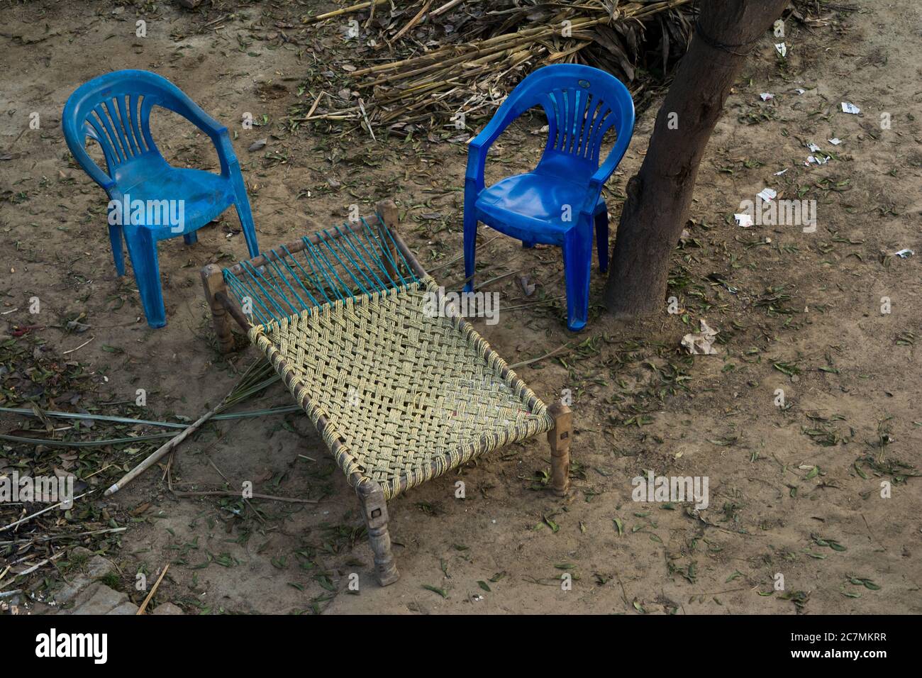 Charpai - cama tradicional de estilo indio hecha de malla tejida o de cuerda. Cama de desi con dos sillas. Vista aérea Foto de stock