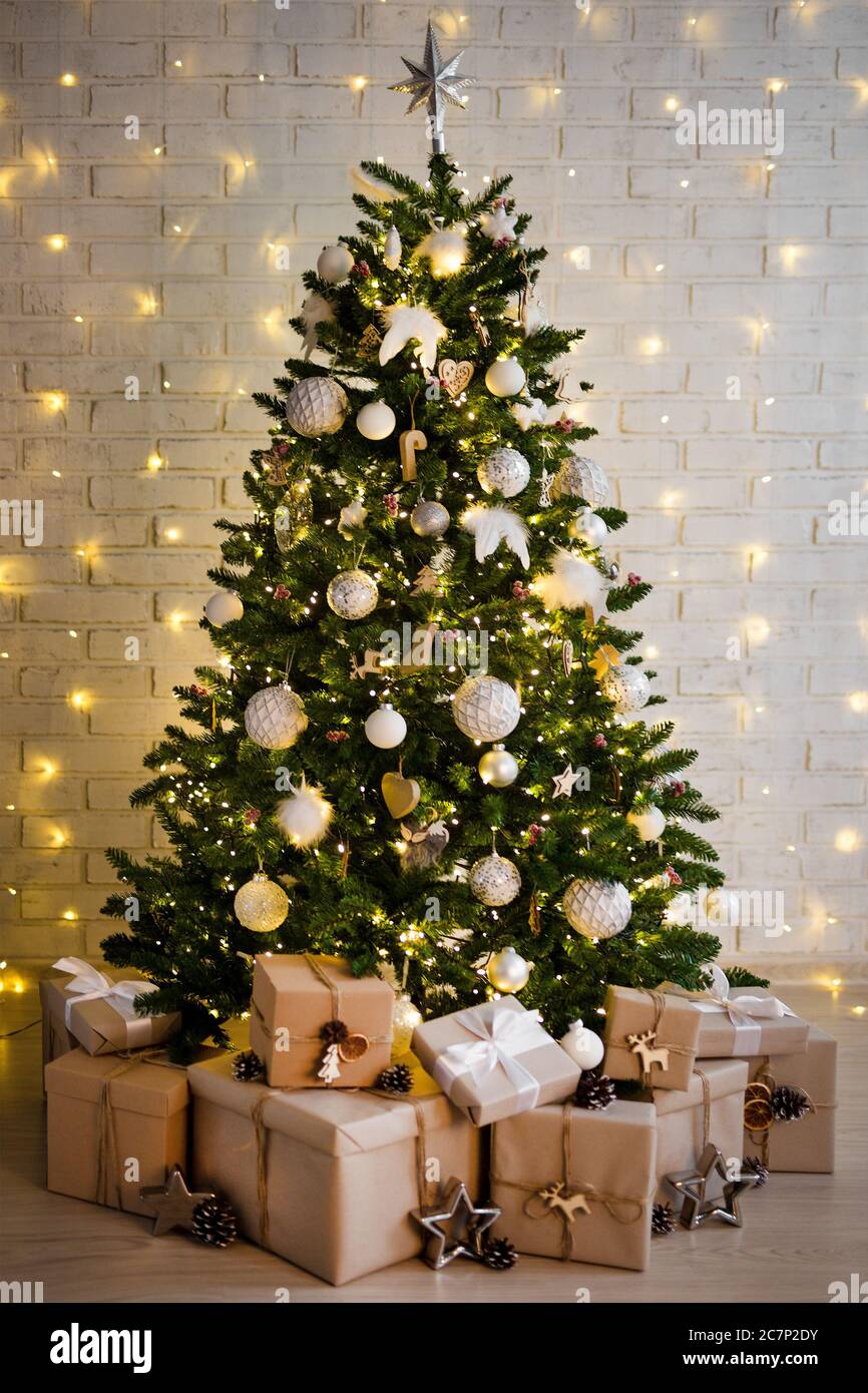 árbol de navidad y montón de cajas de regalo sobre la pared de ladrillo  blanco con luces amarillas Fotografía de stock - Alamy