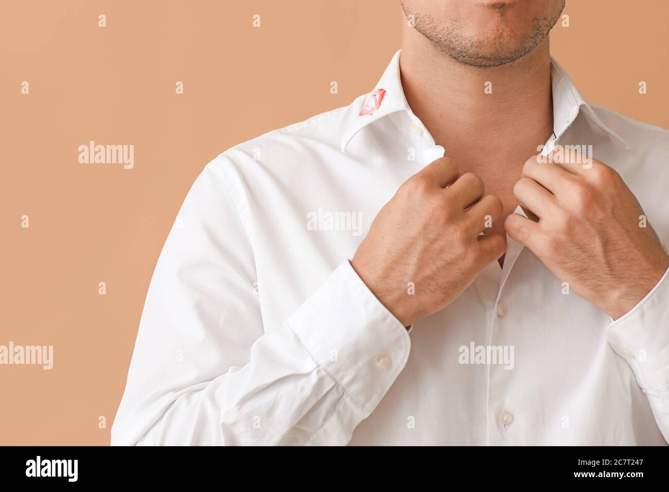 Joven hombre de negocios con labios impresos en cuello de camisa contra fondo de color, primer plano Foto de stock