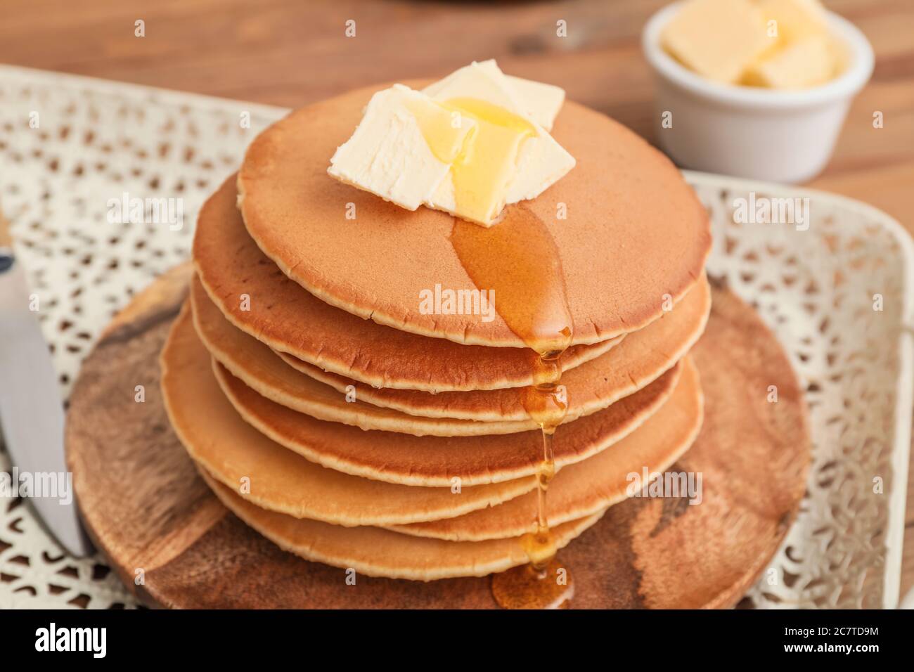 Sabrosas panqueques con mantequilla y miel en la mesa, primer plano Foto de stock