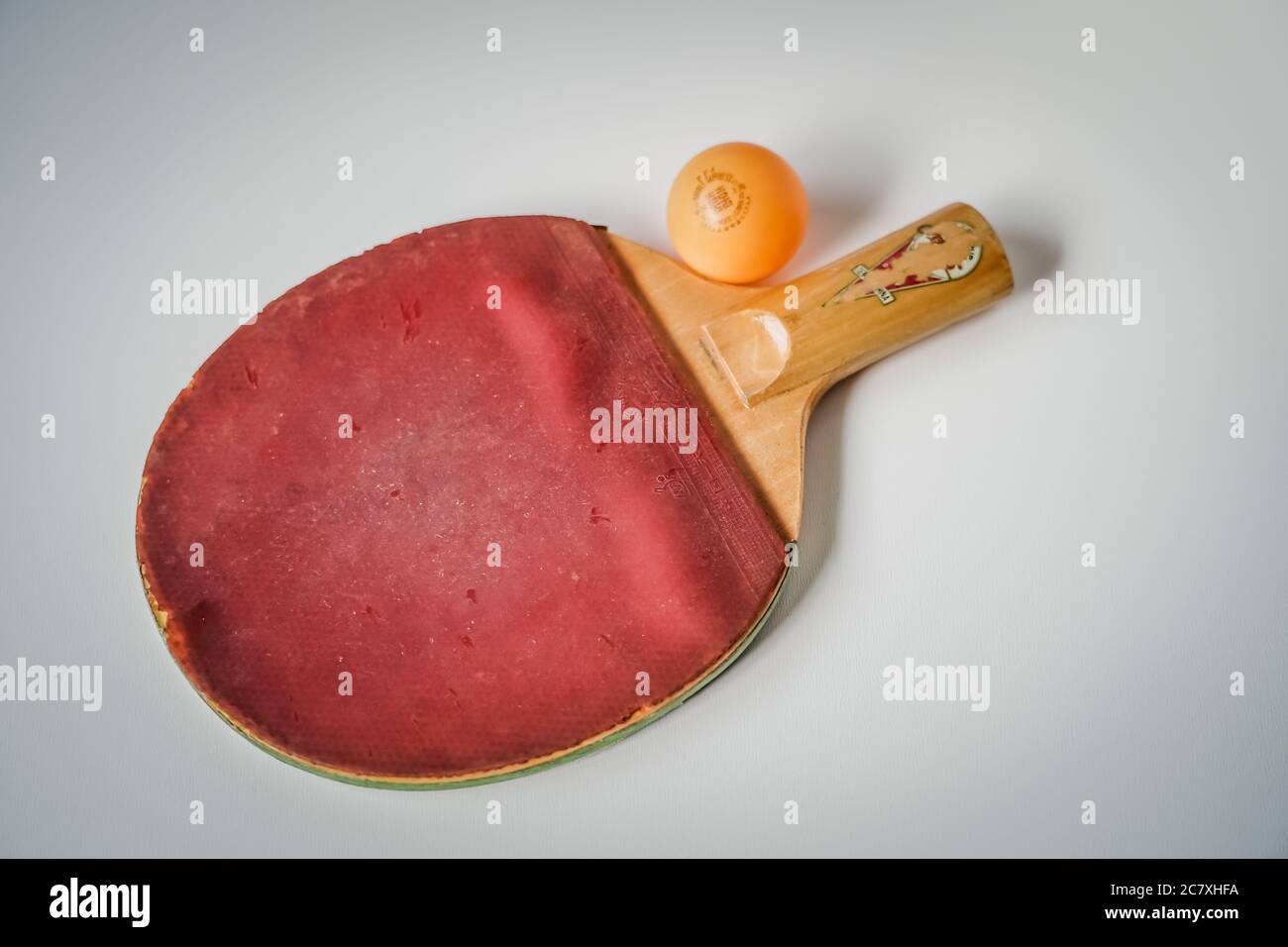 una pelota de ping pong y una paleta de tenis gastada Foto de stock