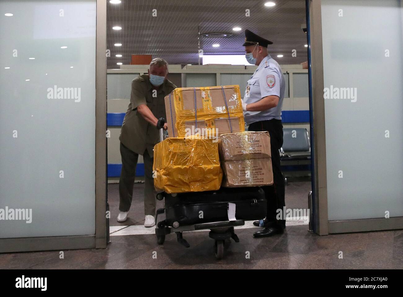 REGIÓN DE MOSCÚ, RUSIA - 20 DE JULIO de 2020: Un viajero ruso entra en el  vestíbulo de llegadas mientras un oficial de policía mira al aeropuerto  internacional de Sheremetyevo después de