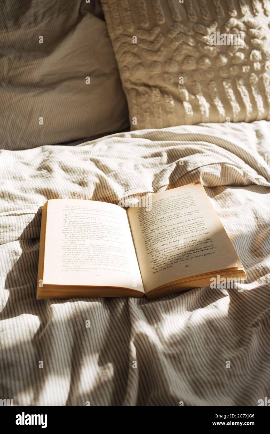 Primer plano de un libro de época en las sábanas de la cama bajo el sol de  la mañana Fotografía de stock - Alamy