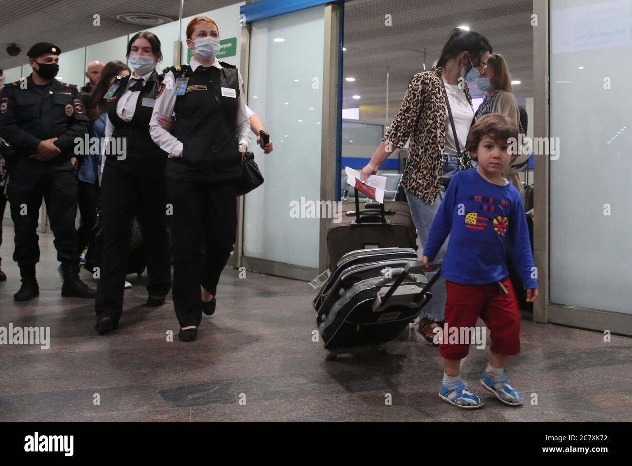 REGIÓN DE MOSCÚ, RUSIA - 20 DE JULIO de 2020: Un viajero ruso con un niño  (R) entra en el vestíbulo de llegadas del Aeropuerto Internacional de  Sheremetyevo después de llegar en