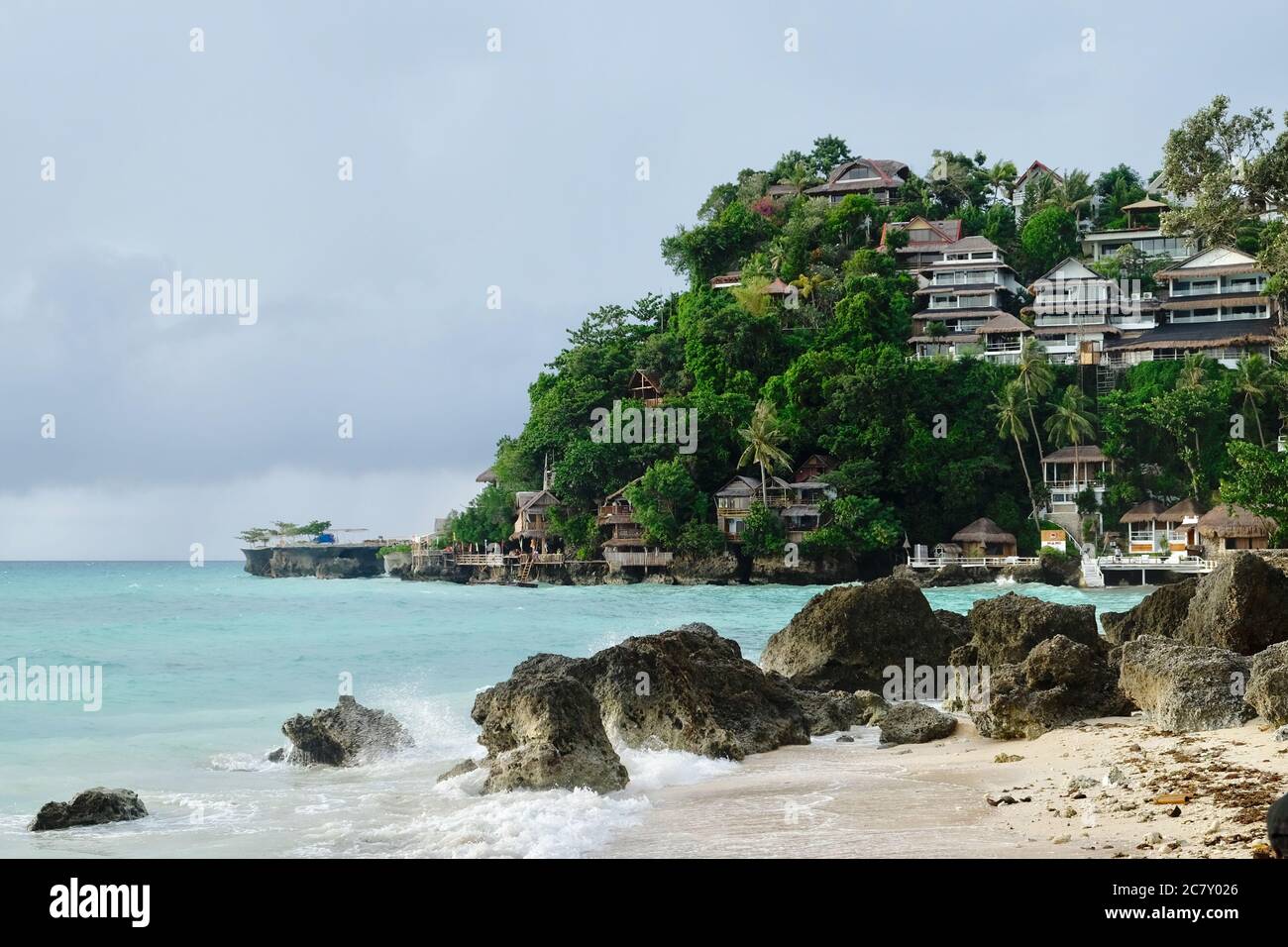 cabañas del hotel en la montaña verde del bosque cerca del mar verde. Las rocas grises, la playa de arena y las olas salpican. Un paraíso muy relajante Foto de stock