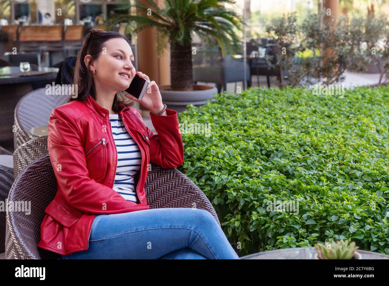 La joven habla con el teléfono y tiene un rostro feliz en un café elegante. Foto de alta calidad Foto de stock