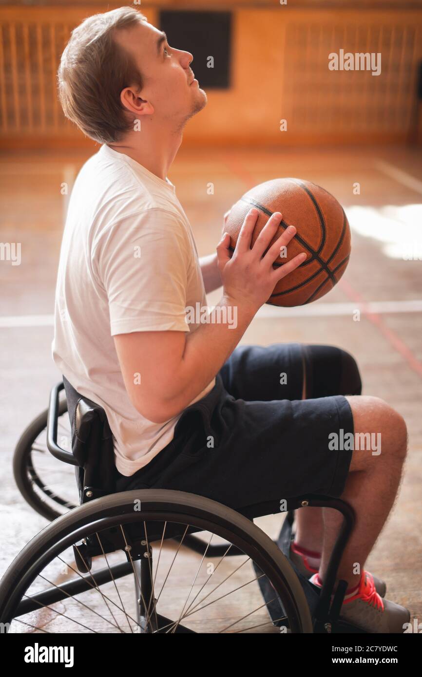 Jugador de baloncesto en silla de ruedas con la bola en su regazo  Fotografía de stock - Alamy