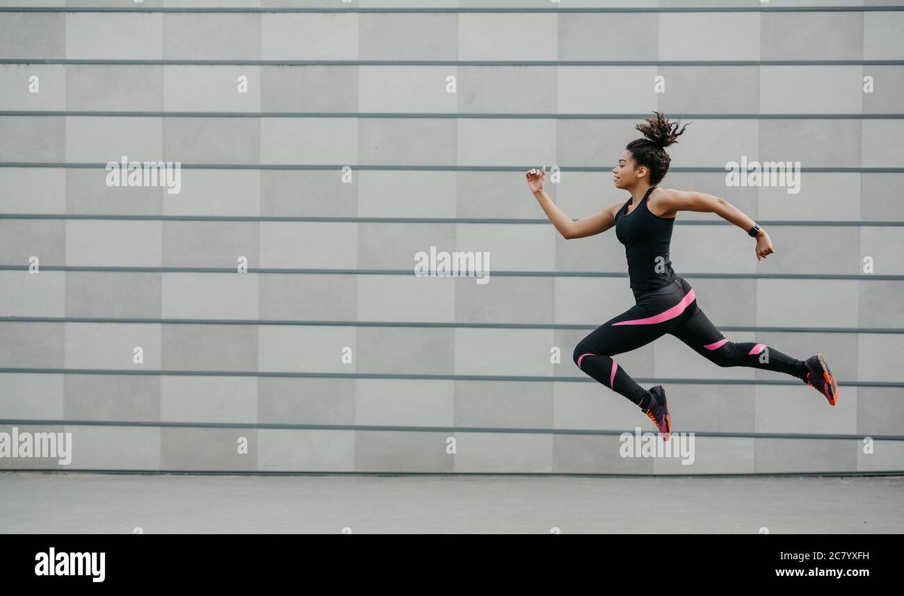 Excelente entrenamiento de running. Niña afroamericana deportiva se congeló el aire sobre el suelo, saltando Fotografía de stock - Alamy