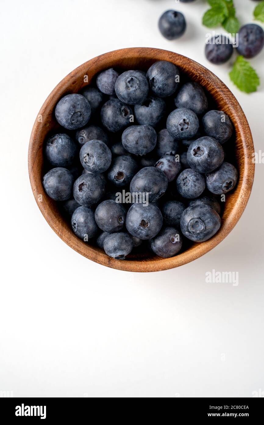 Vista superior de arándanos aislados sobre un fondo blanco, plano sobre disposición con hoja de menta, concepto de diseño saludable. Foto de stock
