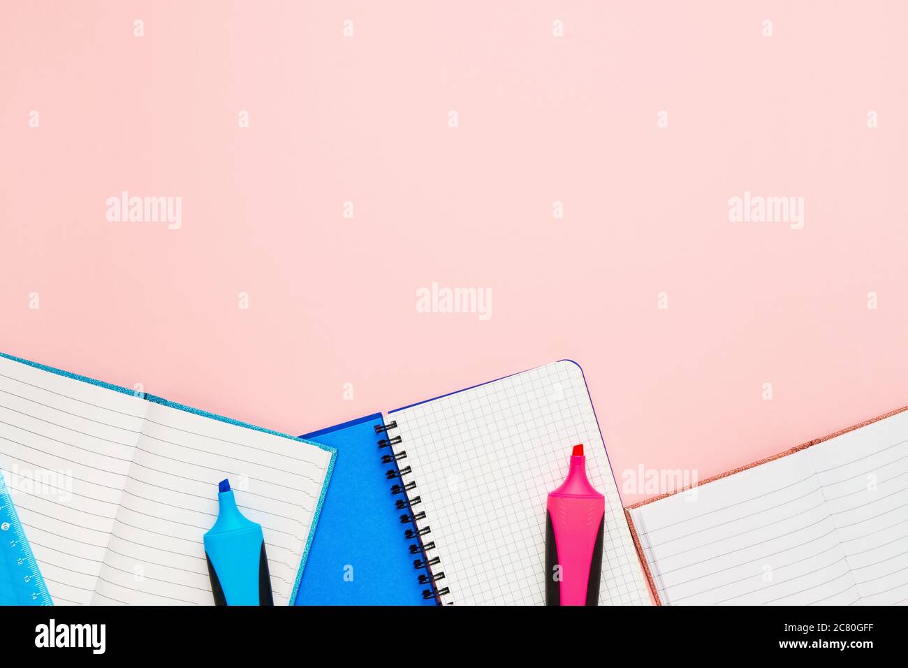 Concepto de vuelta a la escuela. Cuadernos y rotuladores de fieltro sobre fondo rosa pastel. Copiar espacio para texto, vista superior Foto de stock