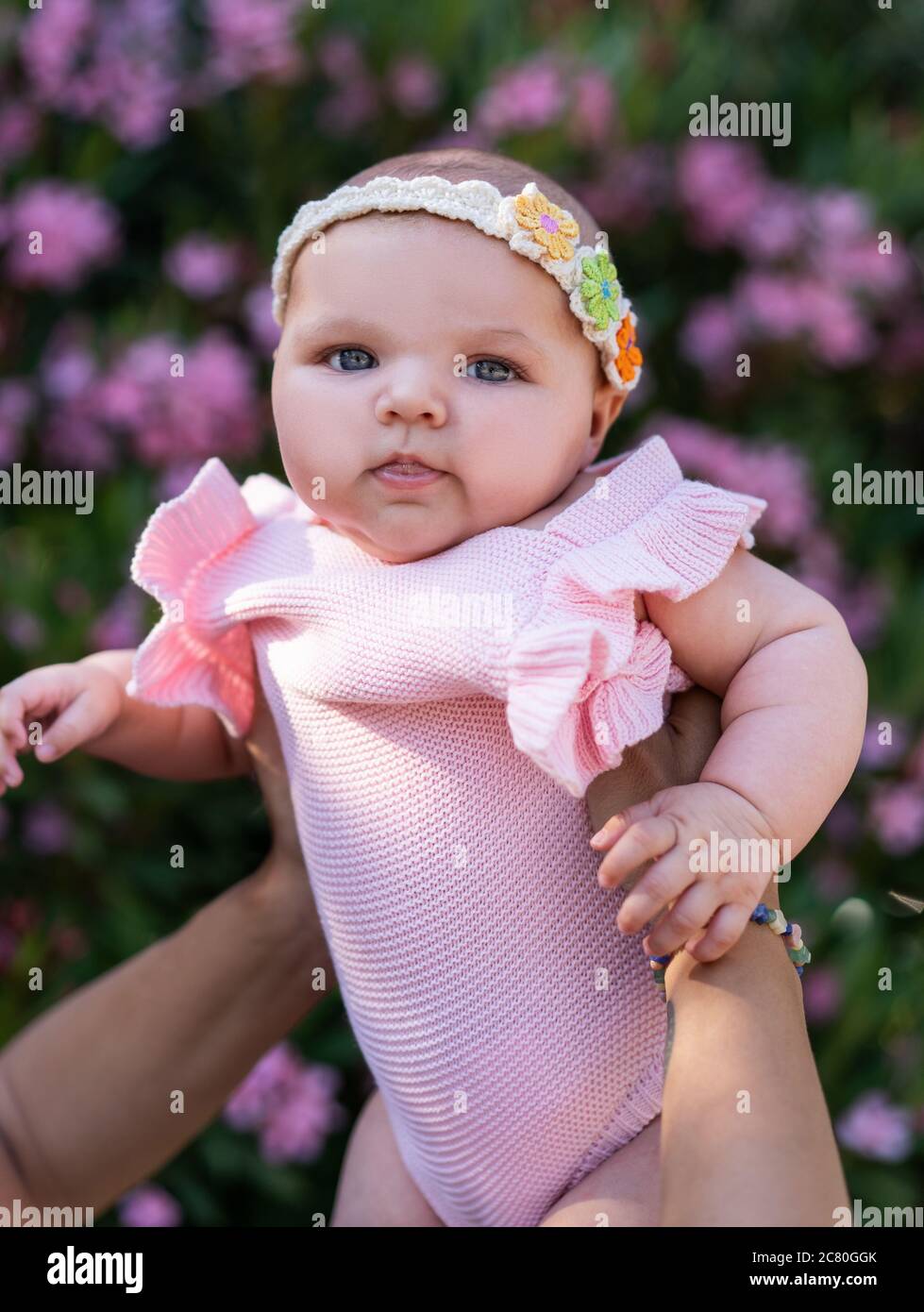 Bebé recién nacido ropa de punto rosa y cabeza accesorio en los brazos de la mujer Fotografía de - Alamy