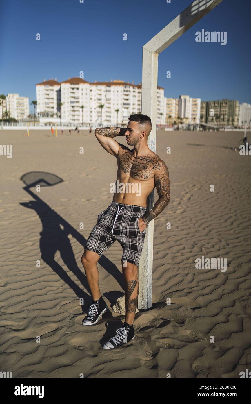 Una foto vertical de un atractivo hombre caucásico con mangas tatuadas  caminando durante el día Fotografía de stock - Alamy