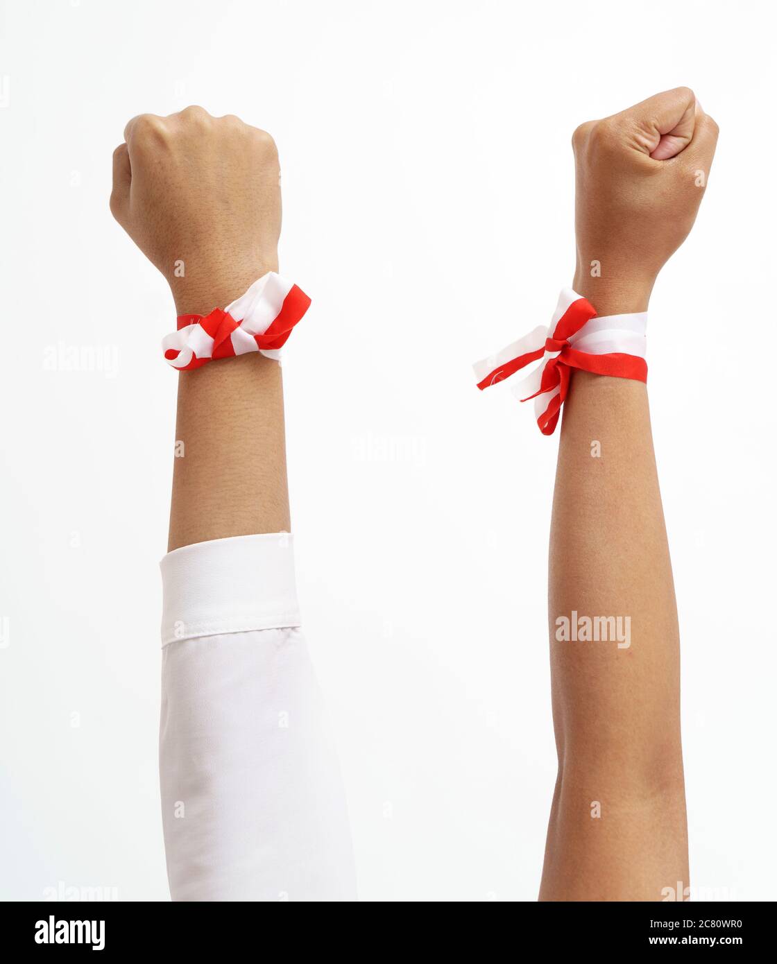 grupo de manos juntas con cinta roja y blanca indonesia en una muñeca.  concepto de unidad Fotografía de stock - Alamy