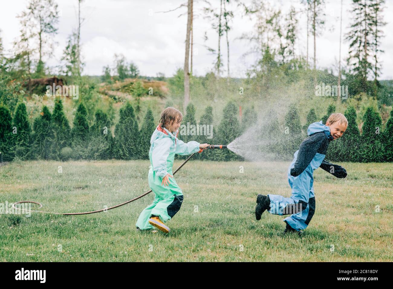 Hermana Rociando A Su Hermano Con Una Manguera Mientras Jugaba La Lluvia Fotografía De Stock Alamy 4284