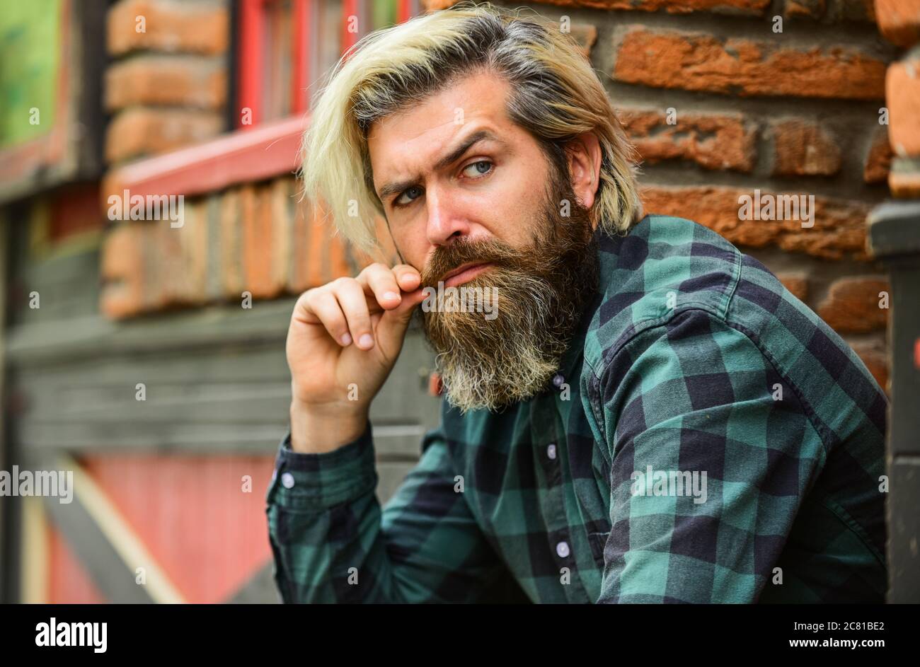 Camisa de cuadros de hombre bajista. Hipster teñido de pelo y barba. Hombre de informal. Hipster en gafas sol. Peluquería y peluquería. Brutal macho con pelo rubio irlandés de fondo