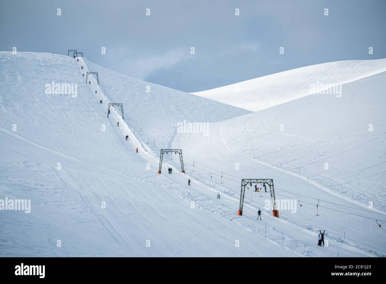 esquiadores subiendo las colinas tiradas por un cable. Un hermoso paisaje nevado de invierno, la naturaleza en todo su poder. Foto de stock