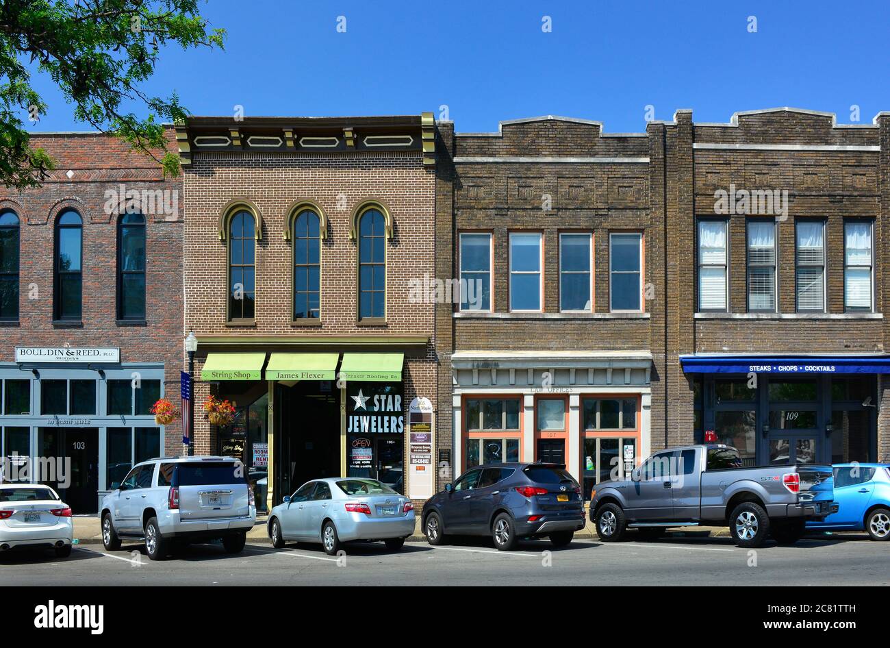 Una pequeña plaza típica americana con coches estacionados a lo largo de los edificios históricos que ahora alberga tiendas de moda y restaurantes en Murfreesboro, TN Foto de stock