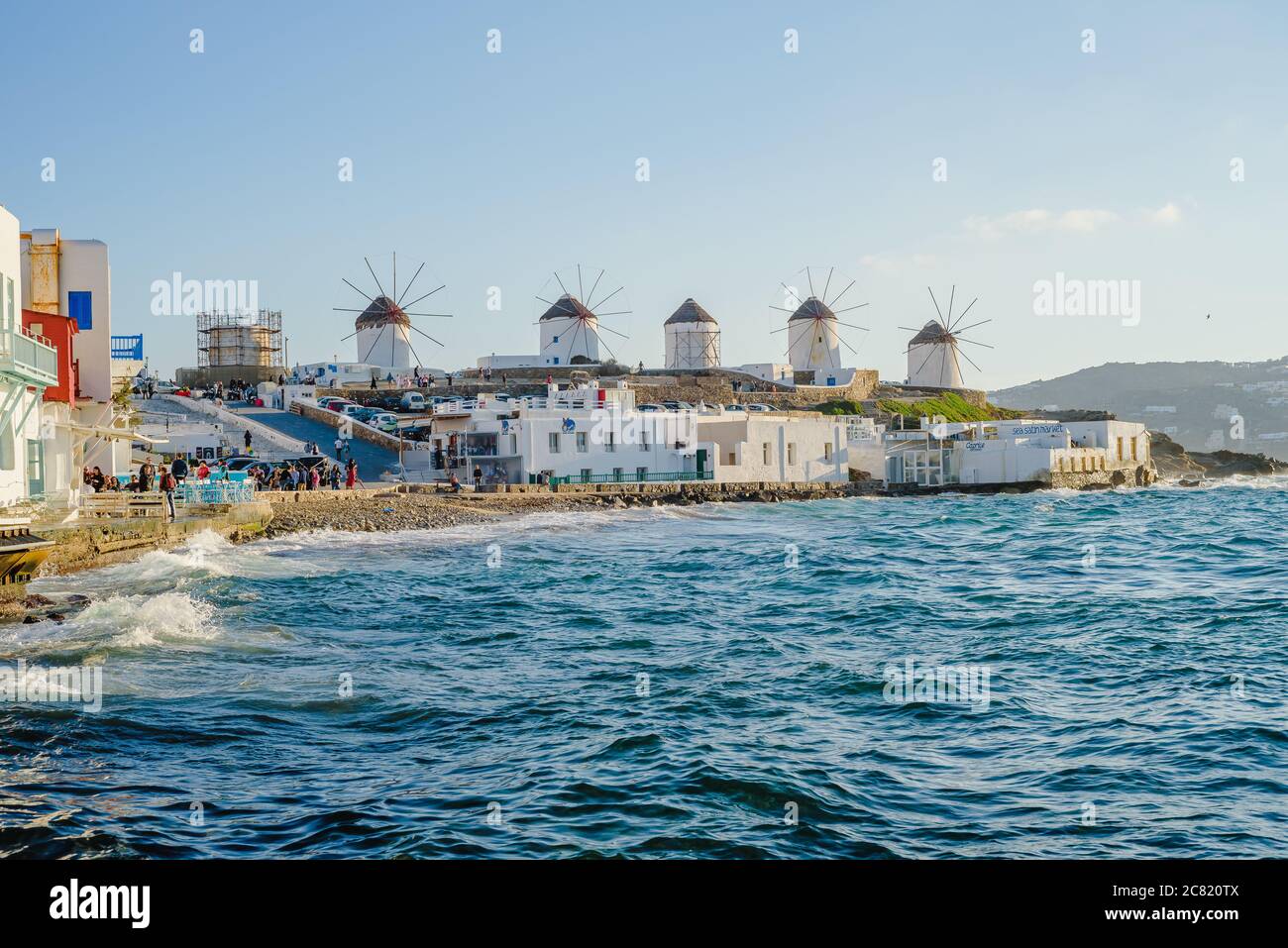 Una serie de molinos en la colina cerca del mar en la isla de Mykonos en Grecia, la atracción principal de la isla Foto de stock