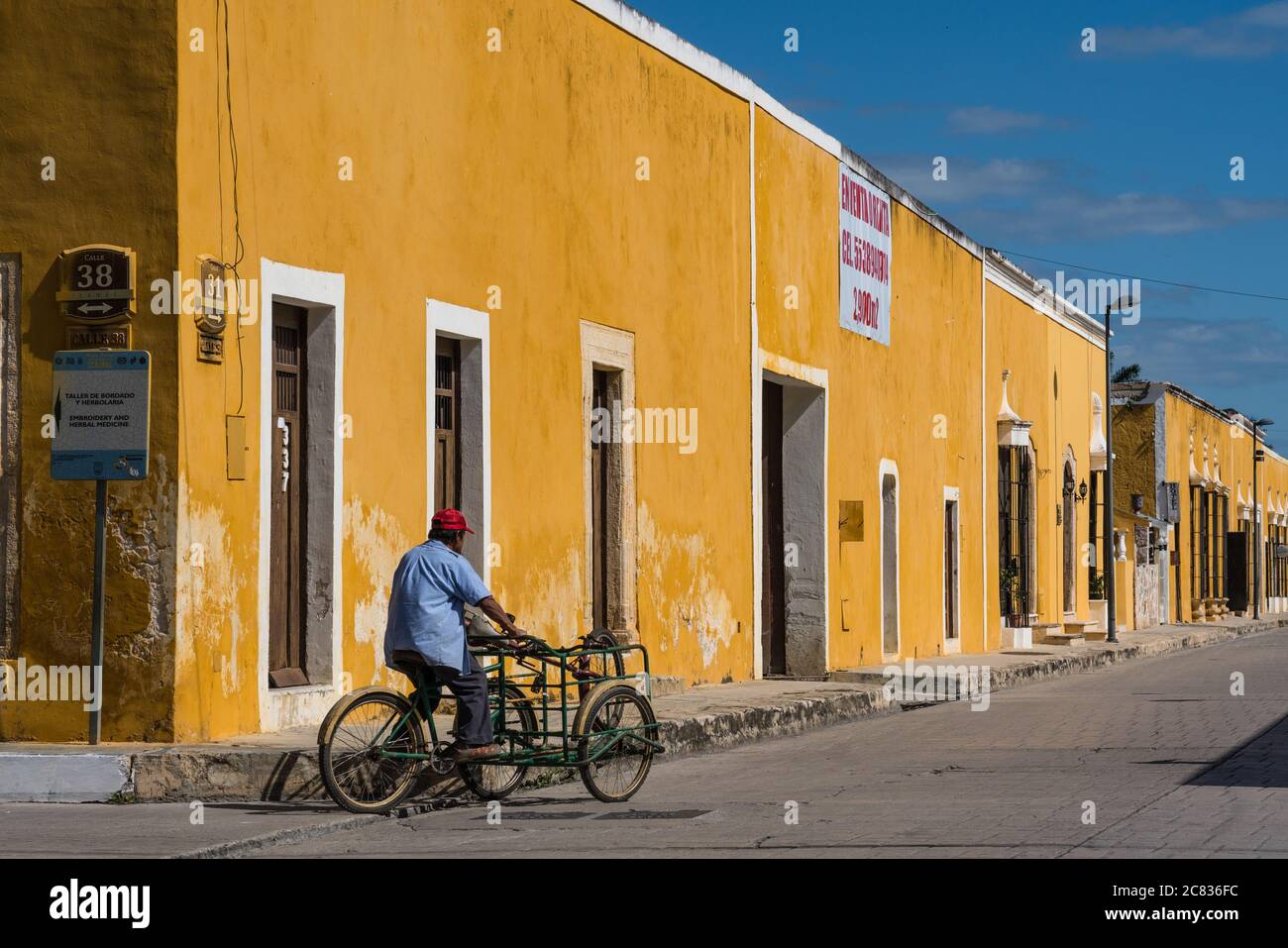 Un hombre monta su triciclo de carga en la calle de Izamal, Yucatán,  México, conocido como el Pueblo Amarillo. La Ciudad histórica de Izamal es  un mundo de la UNESCO he Fotografía