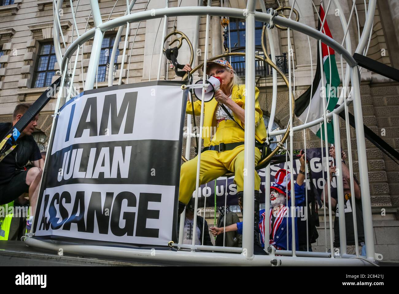 Londres, Reino Unido, 21 de julio de 2020. Dame Vivienne Westwood está enjaezada en una jaula gigante con un signo de "Yo soy Julian Assange", y suspendido 10 pies en el aire frente a la Corte Penal Old Bailey, en protesta por la extradición de Estados Unidos de Julian Assange. Westwood está vestido con un traje de pantalón amarillo, que enfigura la metáfora de la mina de carbón de Canarias, para ilustrar que Assange está siendo sacrificado. Ella posó más tarde delante del viejo Bailey con su mensaje. Crédito: Imageplotter/Alamy Live News Foto de stock