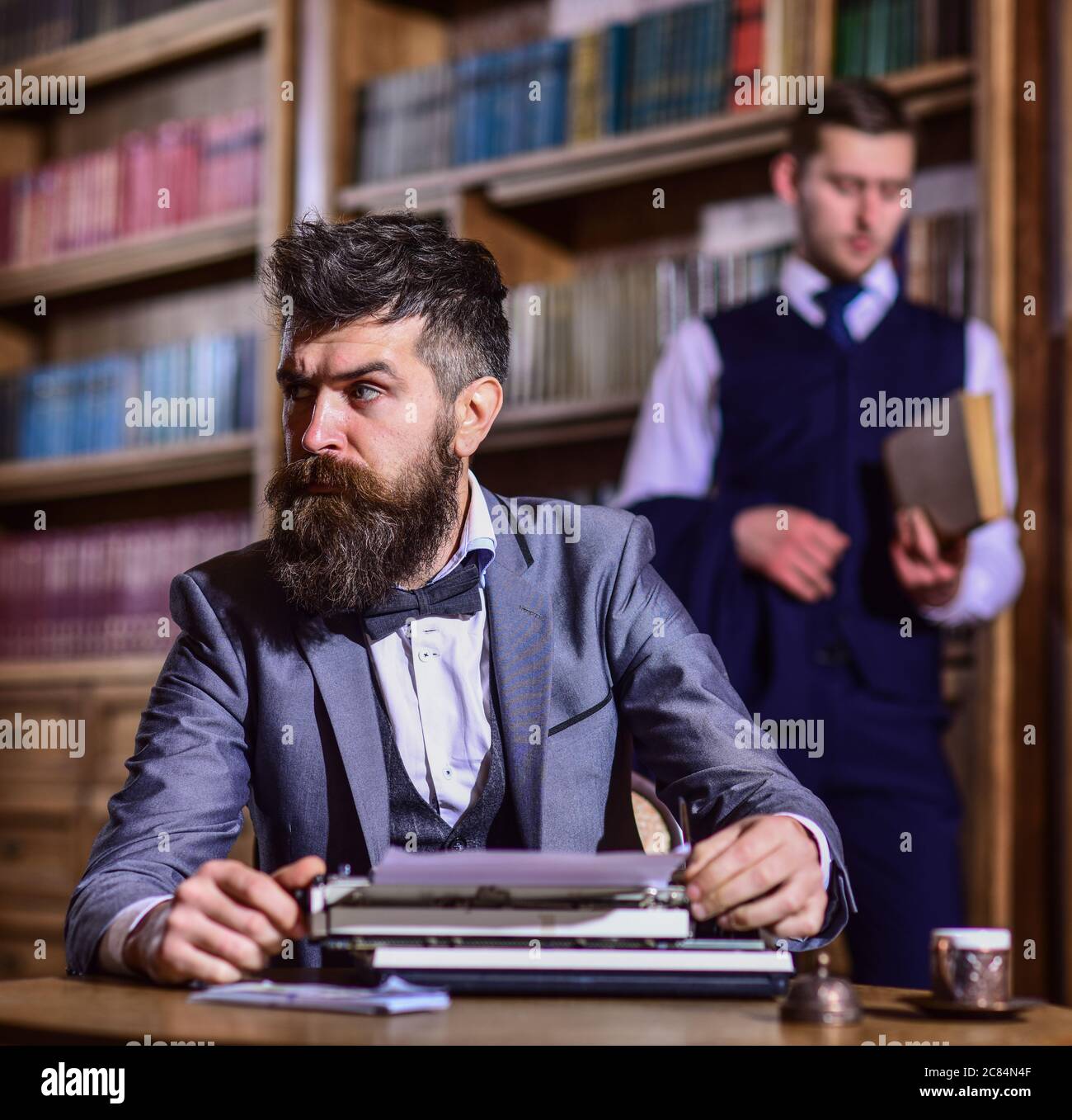 Retrato de guapo escritor con barba. Hombre con traje y pajarita