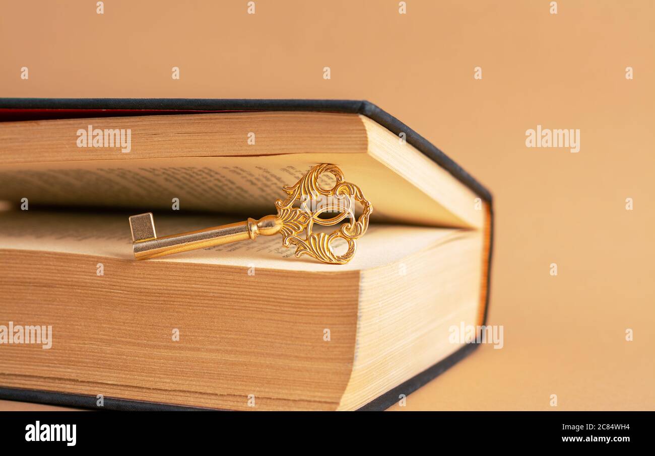 Una vieja y hermosa llave entre las páginas del libro viejo. Foto de stock