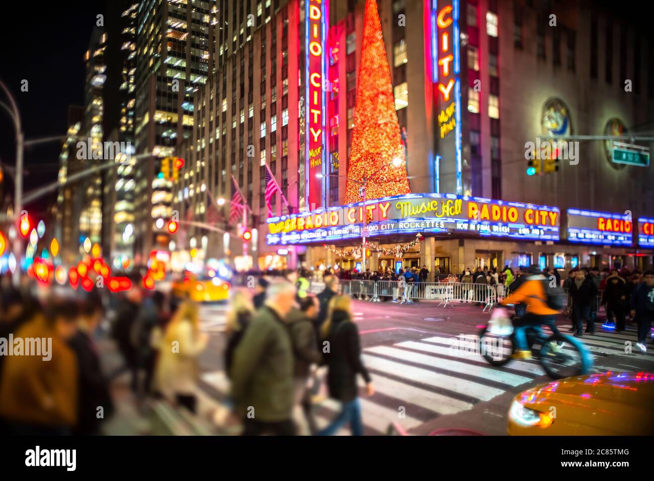 Una multitud de personas cruza la 6th Avenue frente al Radio City Music Hall Foto de stock