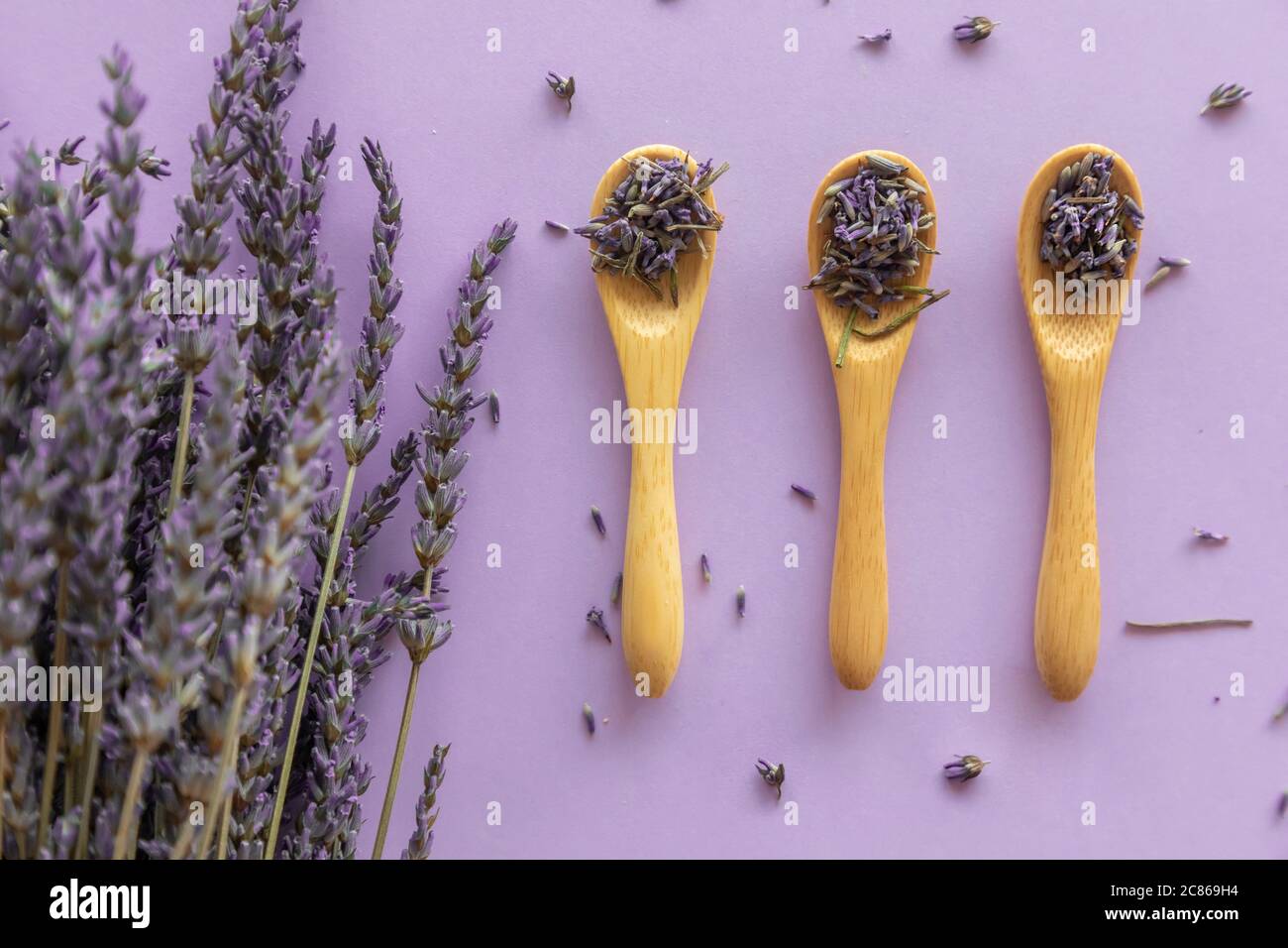 Flor de lavanda seca en cuchara de madera y ramo de lavanda sobre fondo  violeta Fotografía de stock - Alamy
