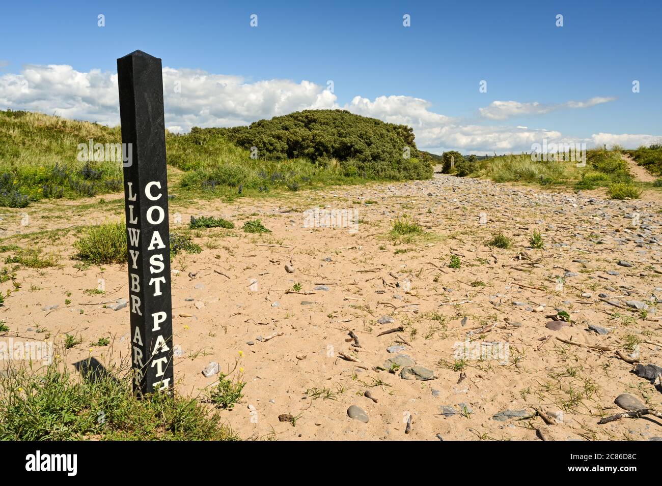Poste de madera que Marca la ruta de un camino costero Foto de stock