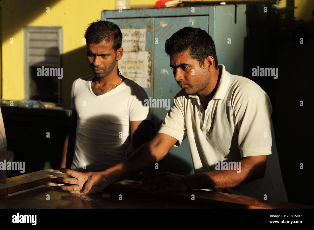 Un hombre adulto indio dedos en la posición de tiro en un juego de carroma Foto de stock