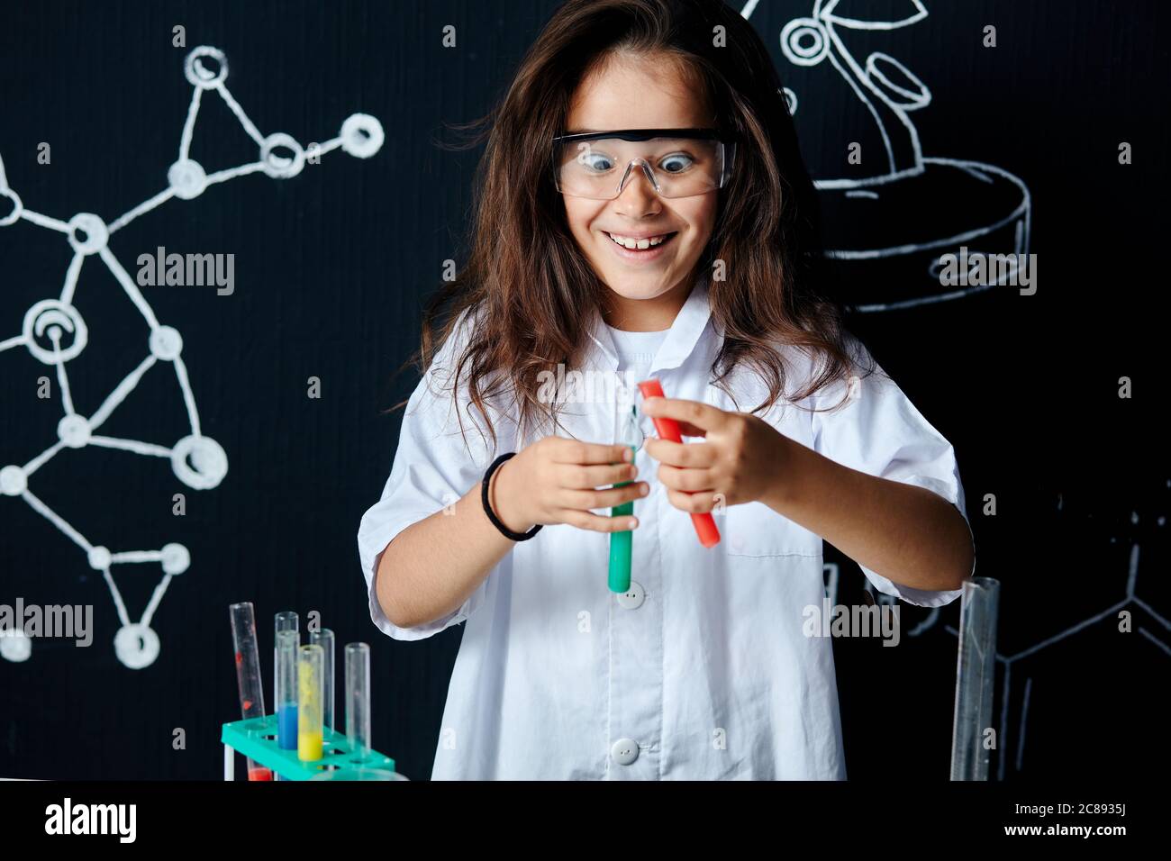 Linda pupila vietnamita femenina en gafas protectoras y uniforme blanco,  haciendo investigación bioquímica en clase de química Fotografía de stock -  Alamy