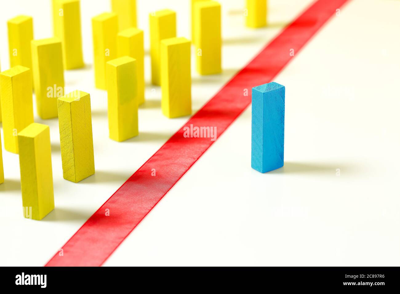 línea roja entre bloques de madera amarillos y azules, concepto de discriminación, diversidad, etc. Foto de stock
