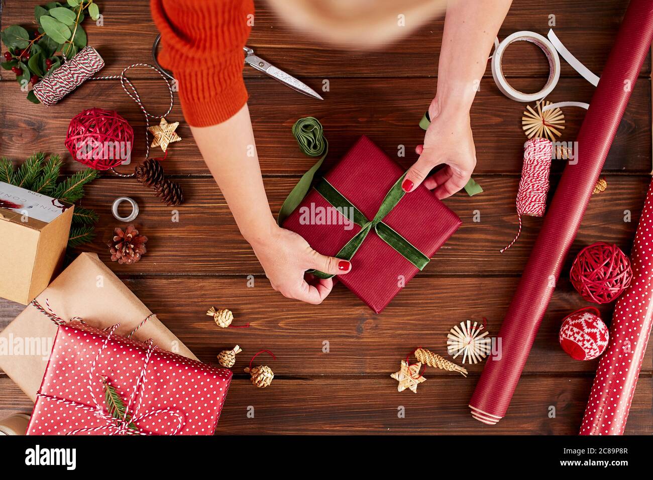 Manos femeninas decorar cajas rojas de regalos para Navidad. Manos de  cerca. Presentar ideas de embalaje Fotografía de stock - Alamy