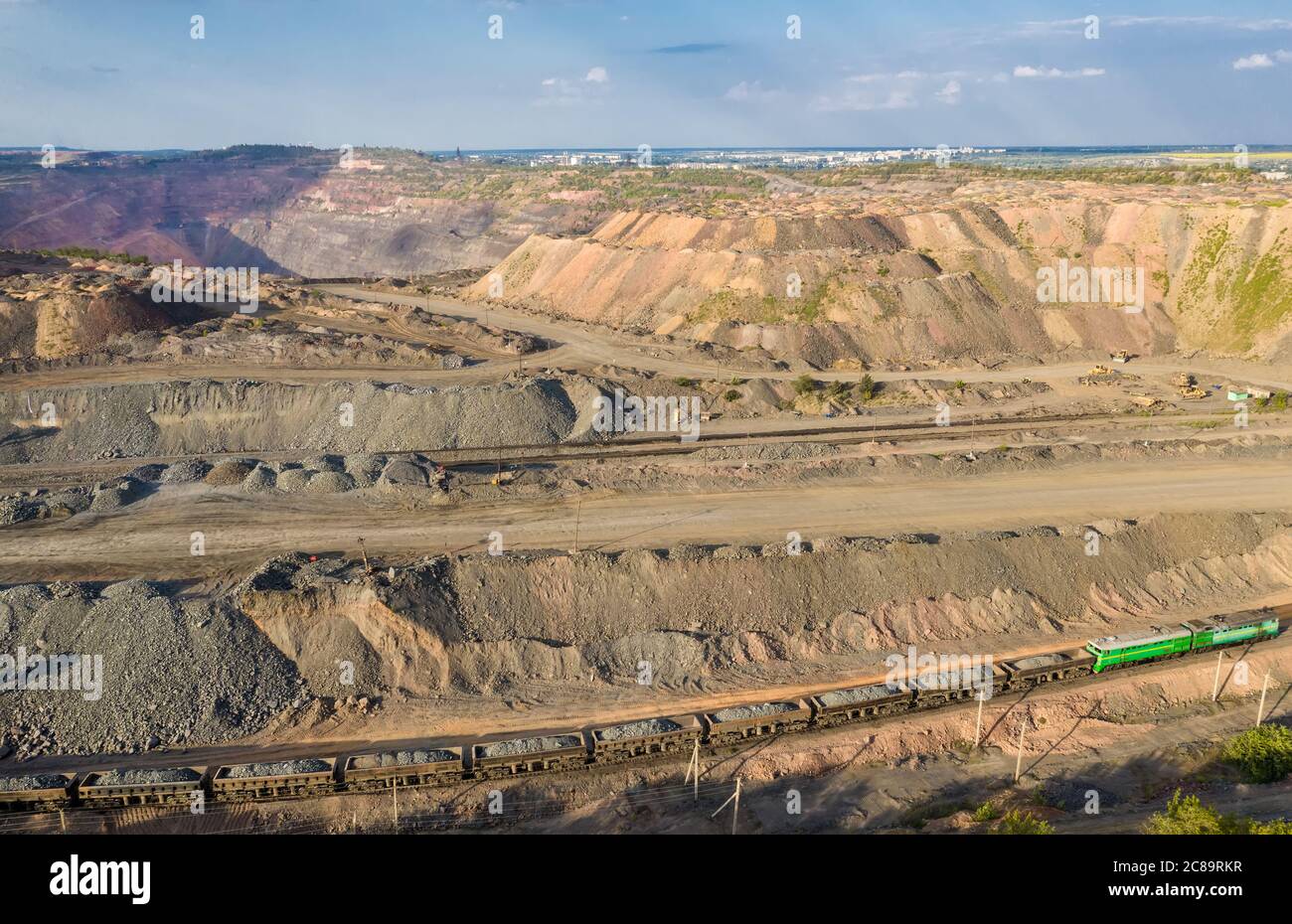 Tren de carga que transporta mineral de hierro en la vista aérea de la cantera minera opencast Foto de stock