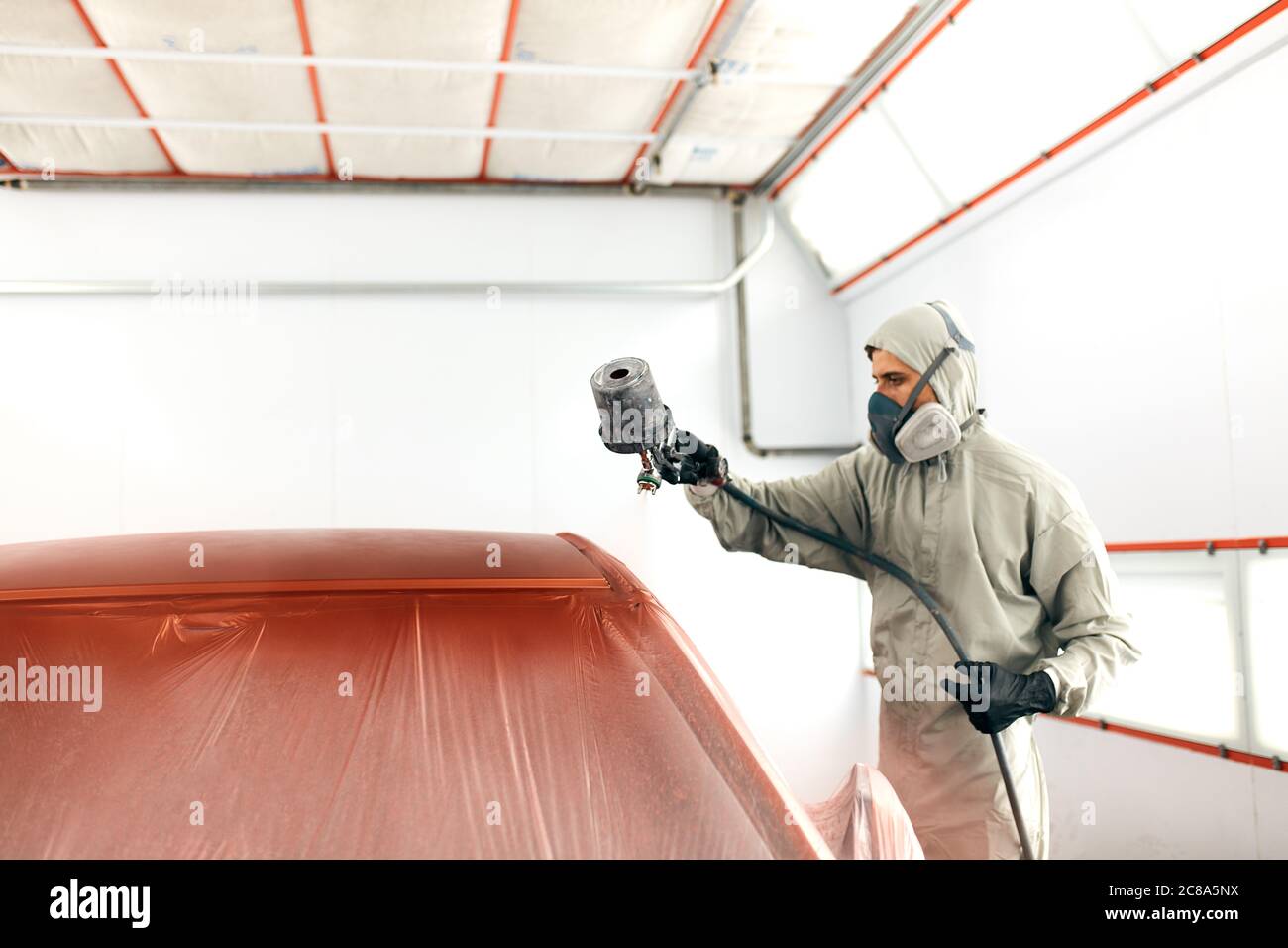Pintor de automóviles en ropa de trabajo protectora y respirador pintar la  carrocería del coche en la sala de pintura Fotografía de stock - Alamy