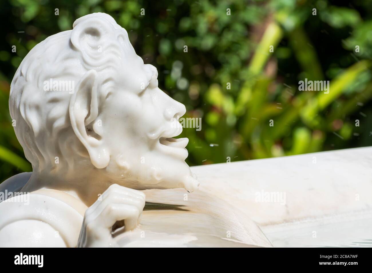 ´s primer plano en la cara de la estatua de mármol que muestra a un hombre sediento bebiendo de una fuente Foto de stock