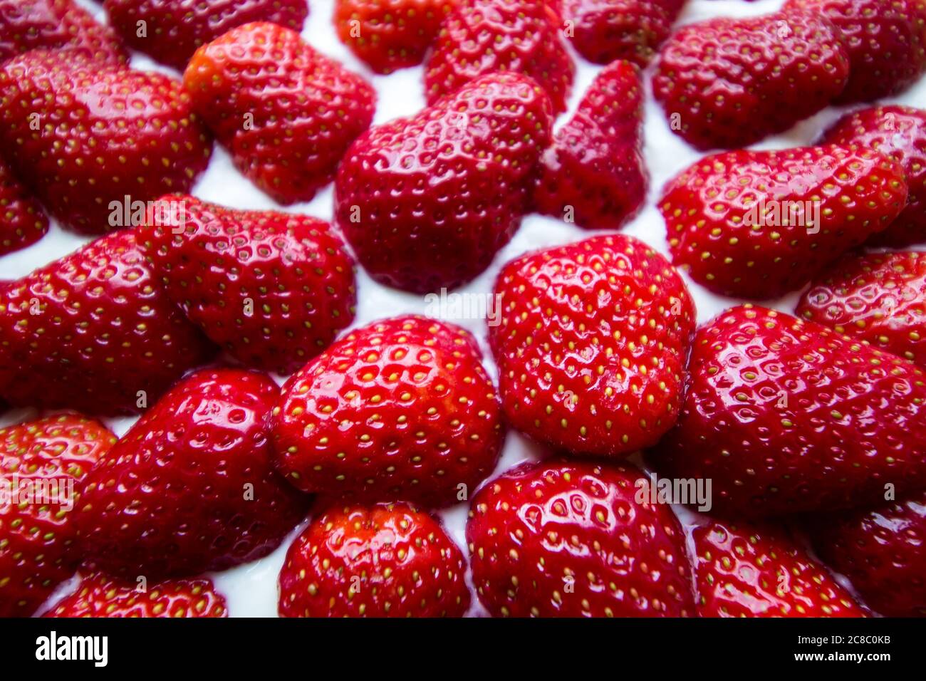 Primer plano de fresas enteras en un pastel desde arriba Foto de stock
