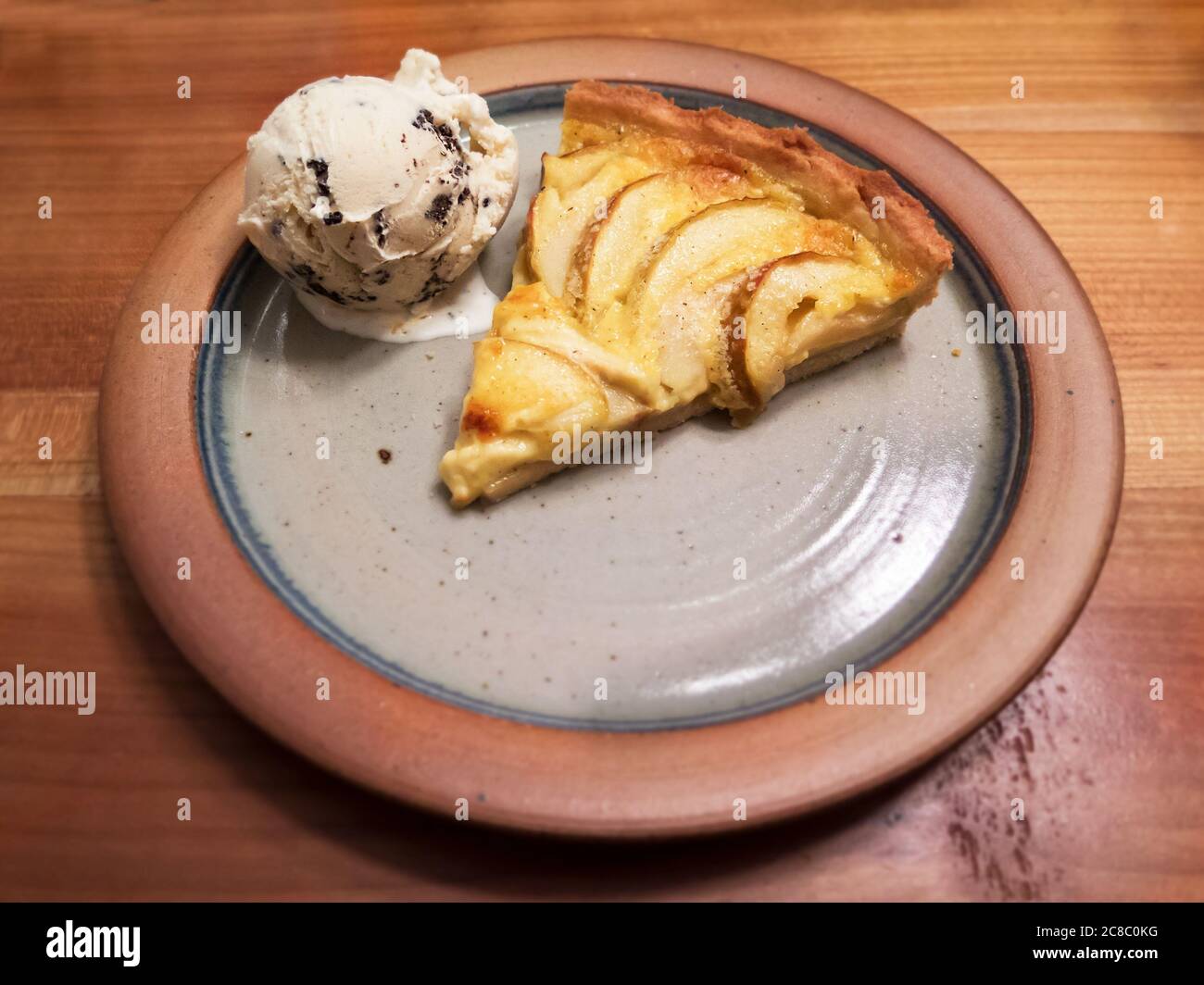 Pieza de tarte de manzana con helado en un plato rústico de arriba Foto de stock