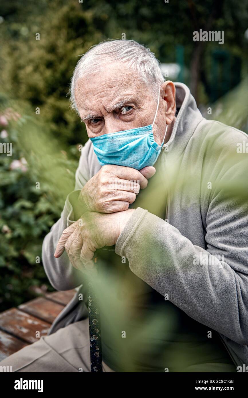 el anciano usa una máscara al aire libre, para no infectarse en una pandemia. Prevención de enfermedades virales. De cerca. Foto de stock