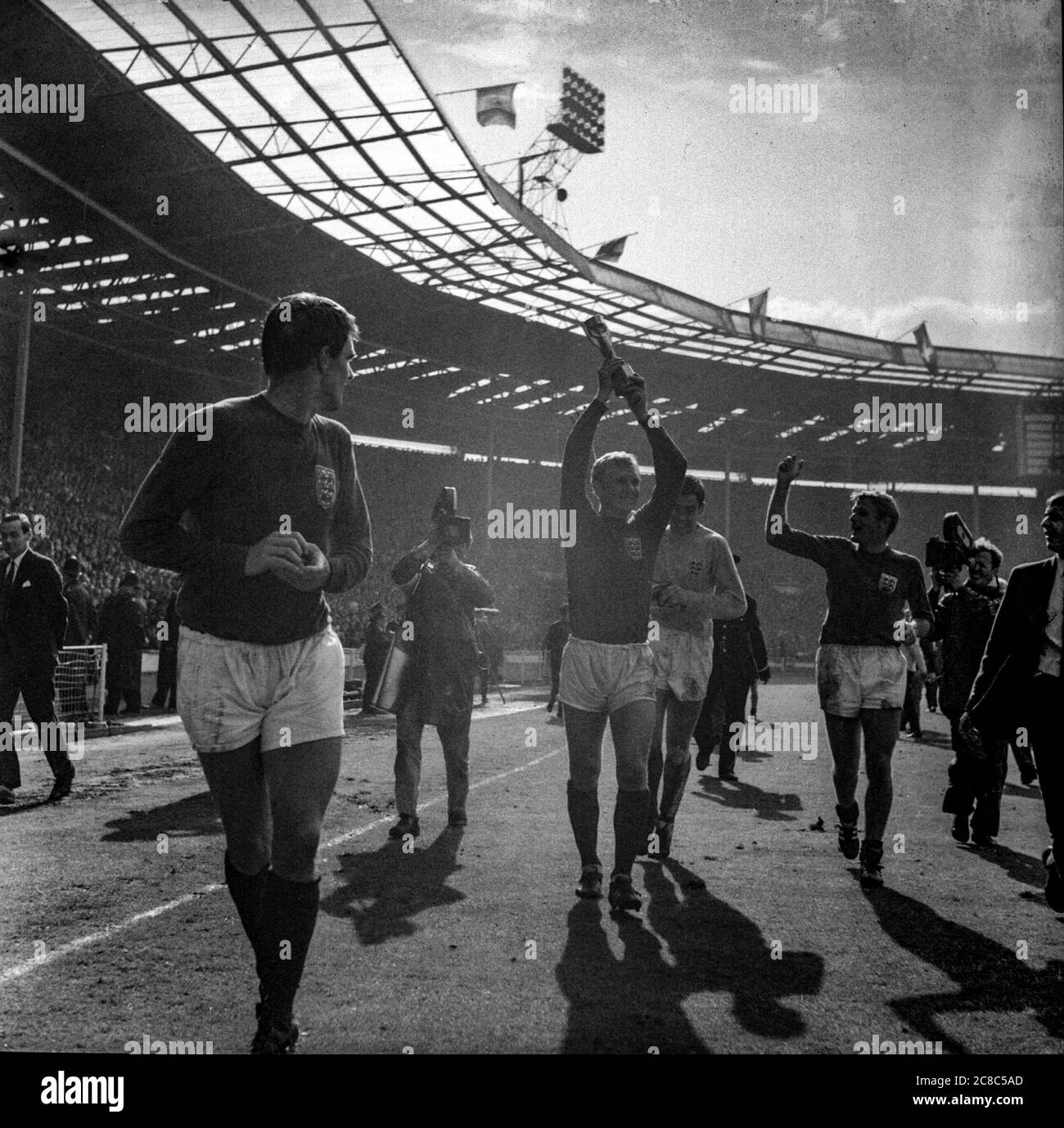 Bobby Moore levanta el trofeo Jules Rimet en un regazo de honor en el estadio Wembley mientras el equipo de fútbol de Inglaterra gana la Copa Mundial de la FIFA de 1966, Geoff Hurst, Gordon Banks y Roger Hunt todos cerca Foto de stock