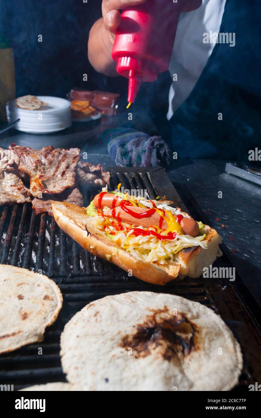 Manos del hombre preparando las alas de pan tostado en la calle llamada