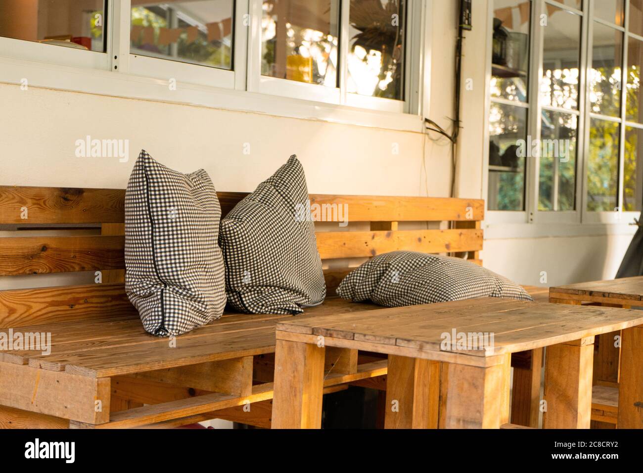 Interior de la cafetería con muebles de palets y almohadas a cuadros  Fotografía de stock - Alamy