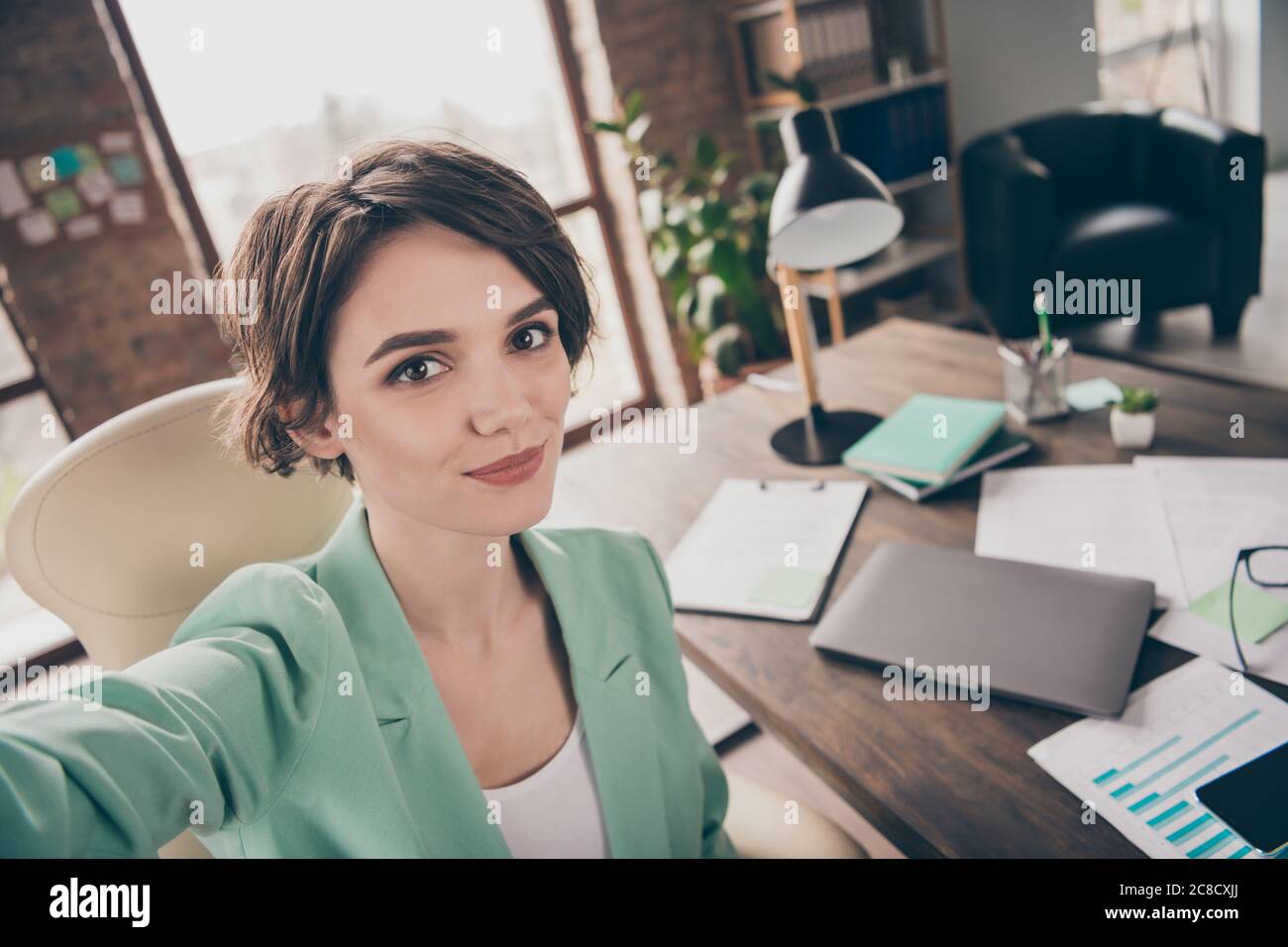 Foto de cerca de casa segura de trabajo chica gerente de marketing agente hacer selfie grabación de inicio desarrollo seminario desgaste chaqueta blazer siéntese en el sillón Foto de stock