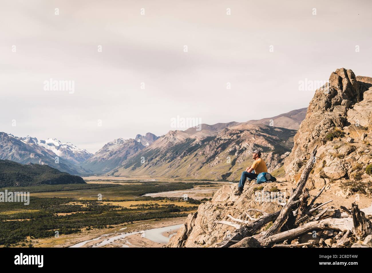 Hiker macho sentado en roca contra Patagonia Andes, Argentina Foto de stock