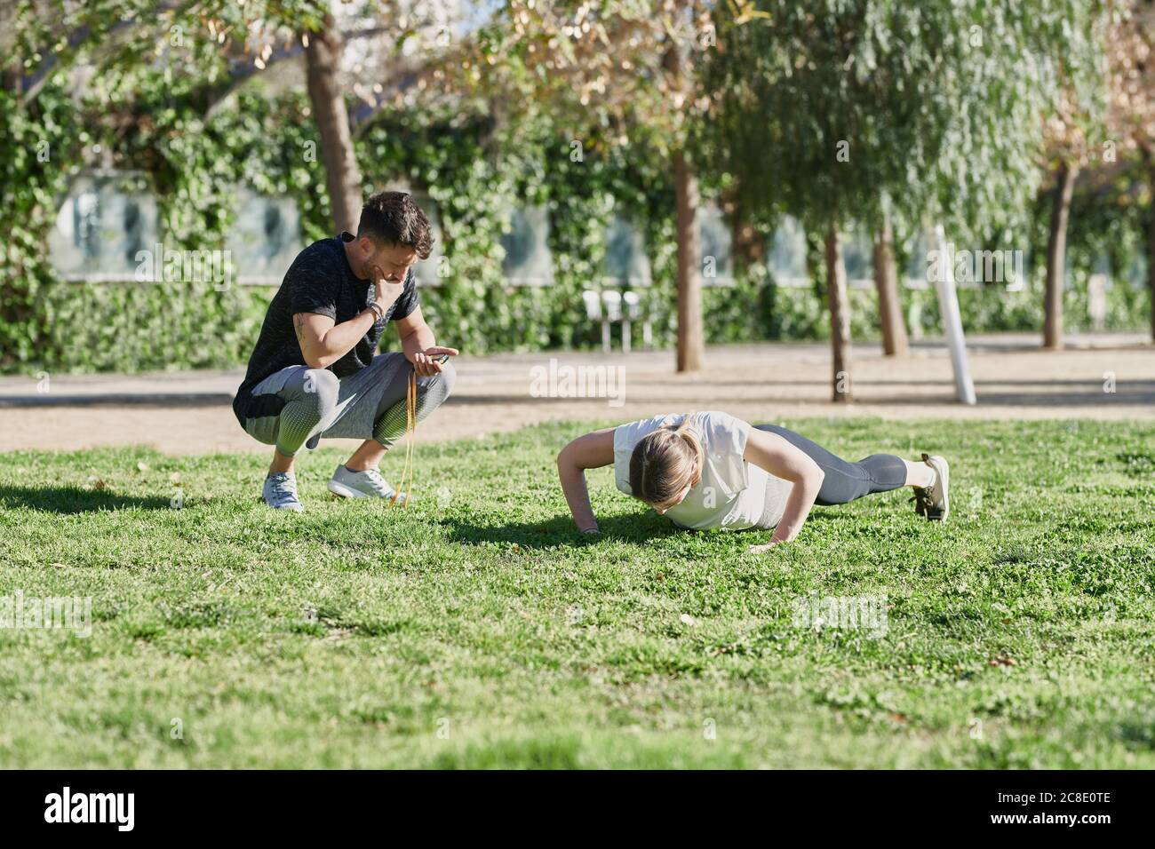 Mujer durante el trabajo con entrenador en el parque Foto de stock